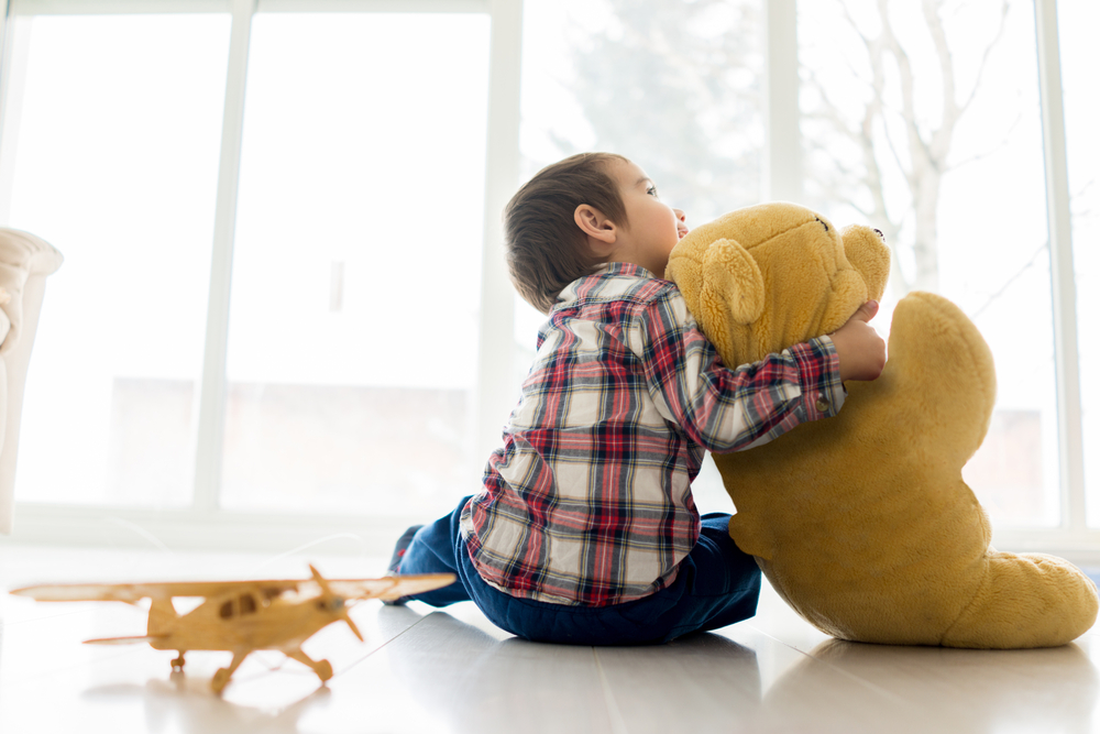 Little baby kid sitting in living room with toy bear Little baby kid sitting in living room with toy bear